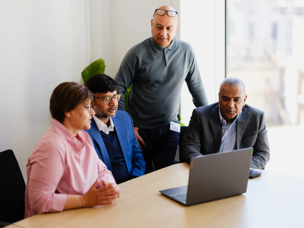 Leadership team reviewing financial data on laptop during a fractional CFO strategy session in India focused on business growth