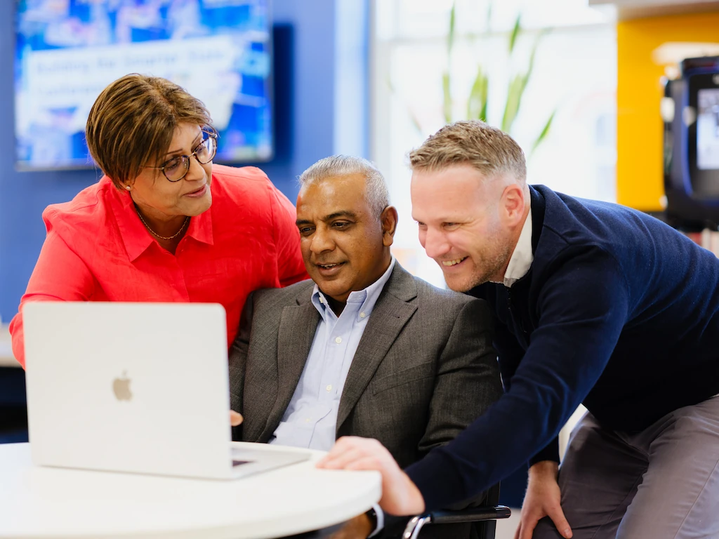 Business team reviewing financial data on laptop during a fractional CFO strategy collaboration session